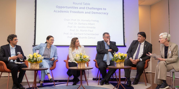 Sechs sitzende Menschen bei einer Podiumsdiskussion