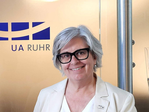 Prof. Dr. Karen Shire in front of the door of the UA Ruhr Liaison Office Latin America