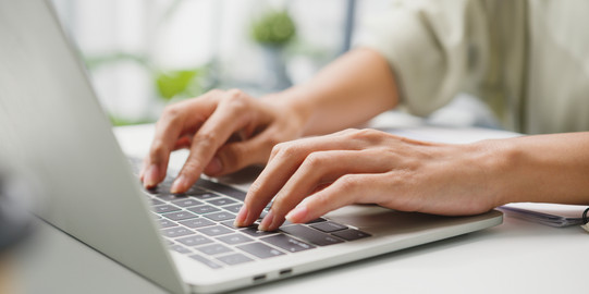 Schreibende Frau am Laptop