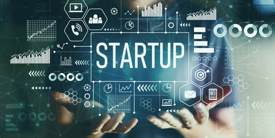 Hände, die ein Display mit dem Wort „Startup“ halten
