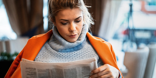 Frau beim Zeitunglesen