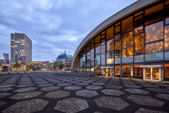 Modernes, beleuchtetes Gebäude mit Stadt im Hintergrund